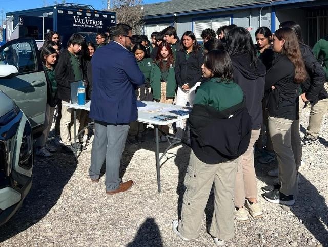 Group huddled at a table with one person leading