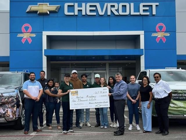Prize cheque handover outside Chevrolet showroom