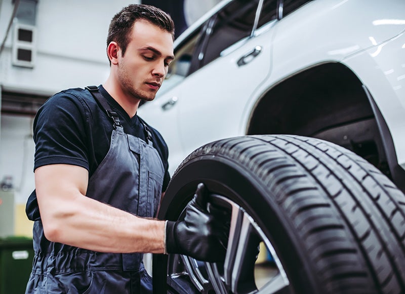 Technician fixing a car tire with precision